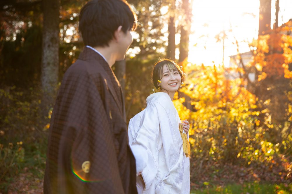 黄葉の真鍋庭園を歩く白無垢の花嫁と新郎