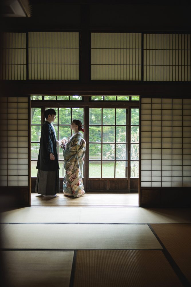 旧永山邸の縁側に立つ和装のふたり