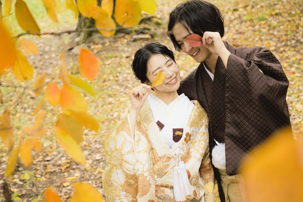 紅葉の鳥沼公園で葉を手にした和装のふたり